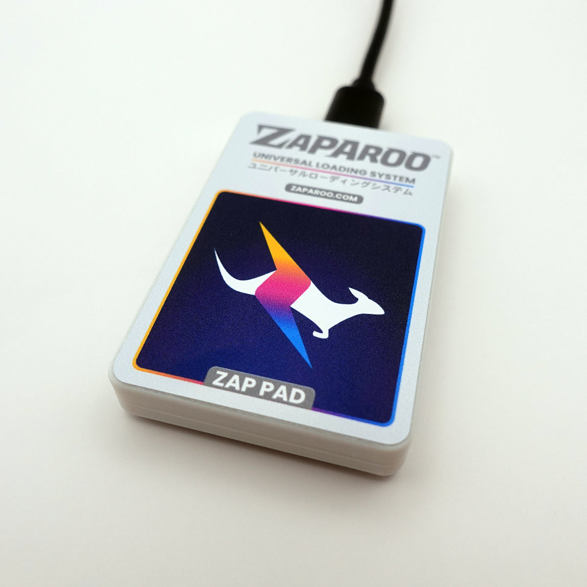 A front shot of an Arctic white Zap Pad with the included USB cable plugged in.